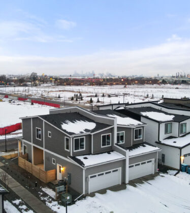 Wide angle of residential development with duplex buildings and snowy on the ground