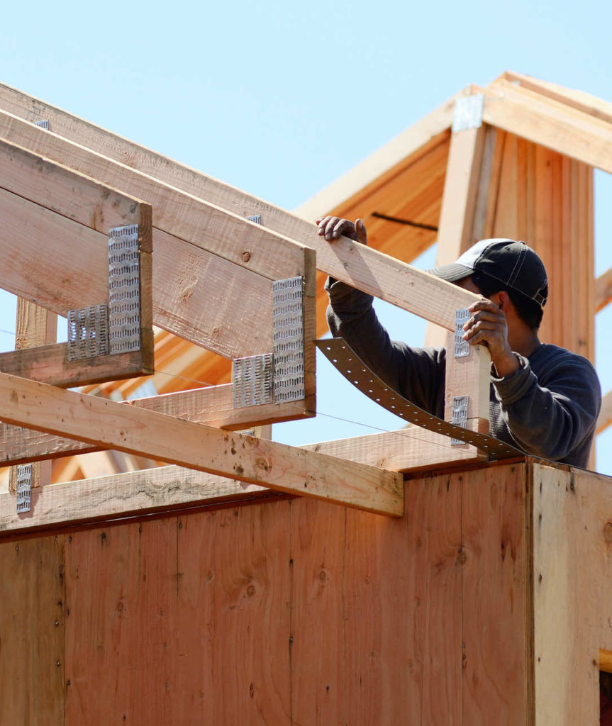 Man building roof of house